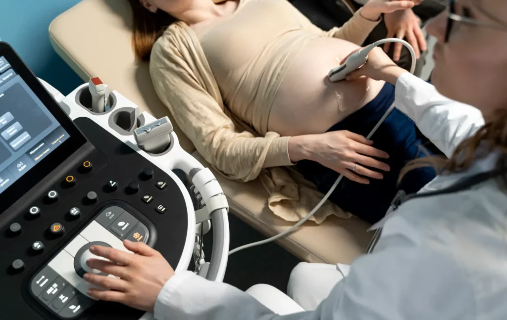 Imagem ilustrativa de médica ginecologista fazendo exame de ultrassom em paciente gestante para diagnosticar a megabexiga fetal. 