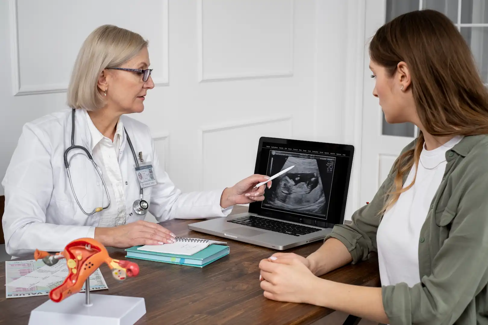 Imagem de m&eacute;dico explicando para paciente resultados de exame de ultrassonografia transvaginal.