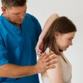 Imagem ilustrativa de médico ortopedista fazendo diagnóstico de tendinopatia calcária no ombro de paciente.
