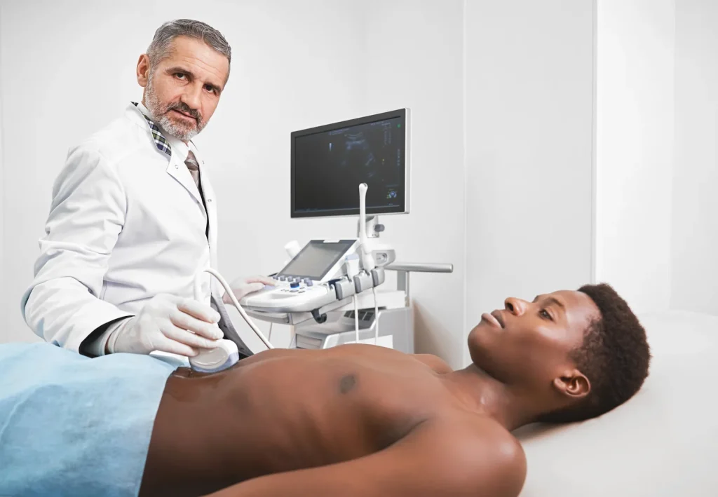 Imagem representativa de médico examinando com ultrassom paciente com sintomas de epididimite.