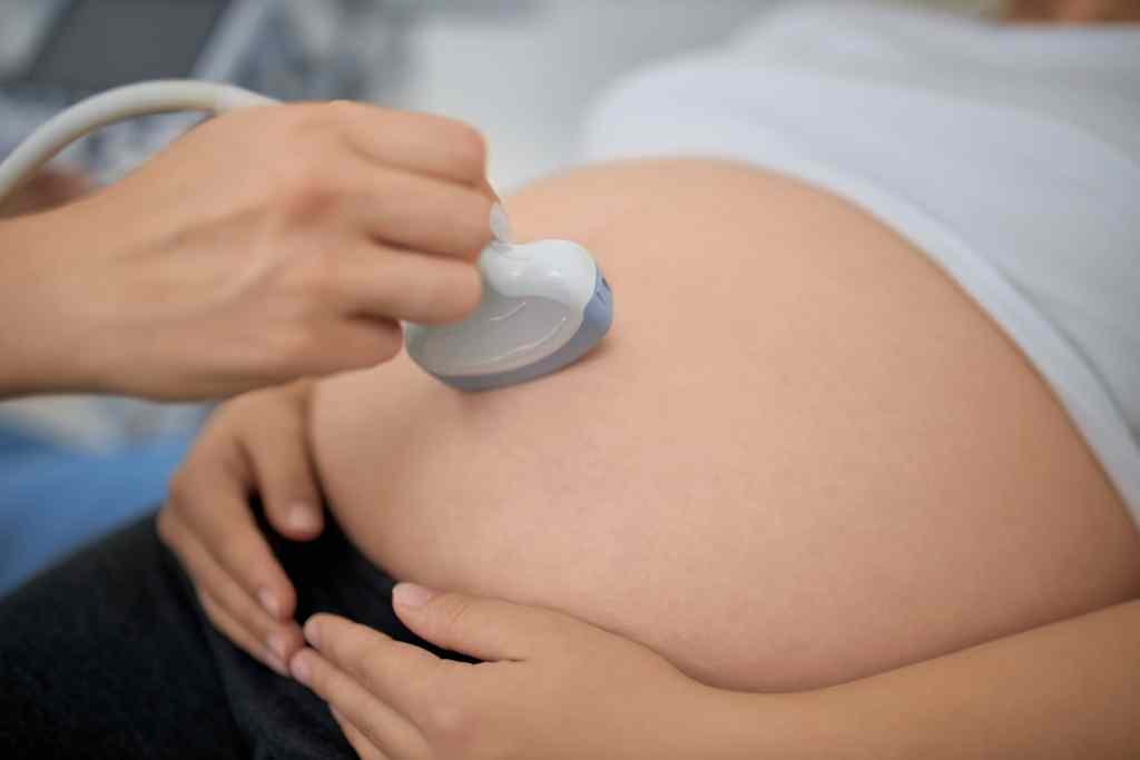 Ultrassom obst&eacute;trico sendo realizado em abdome de gestante durante exame pr&eacute;-natal.