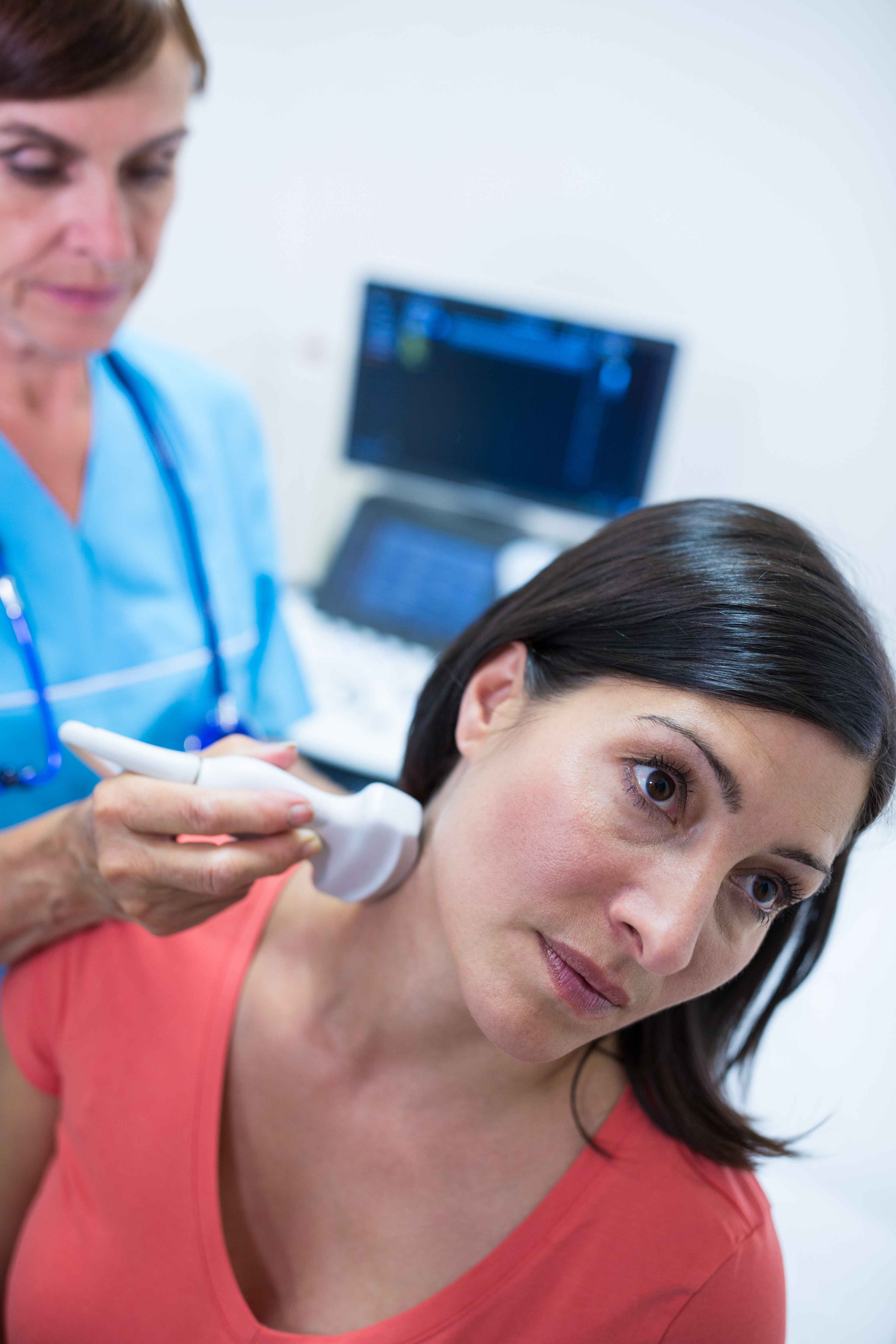 M&eacute;dica realizando ultrassonografia dermatol&oacute;gica na regi&atilde;o do pesco&ccedil;o de paciente, avaliando estruturas cut&acirc;neas com equipamento de imagem em ambiente cl&iacute;nico.