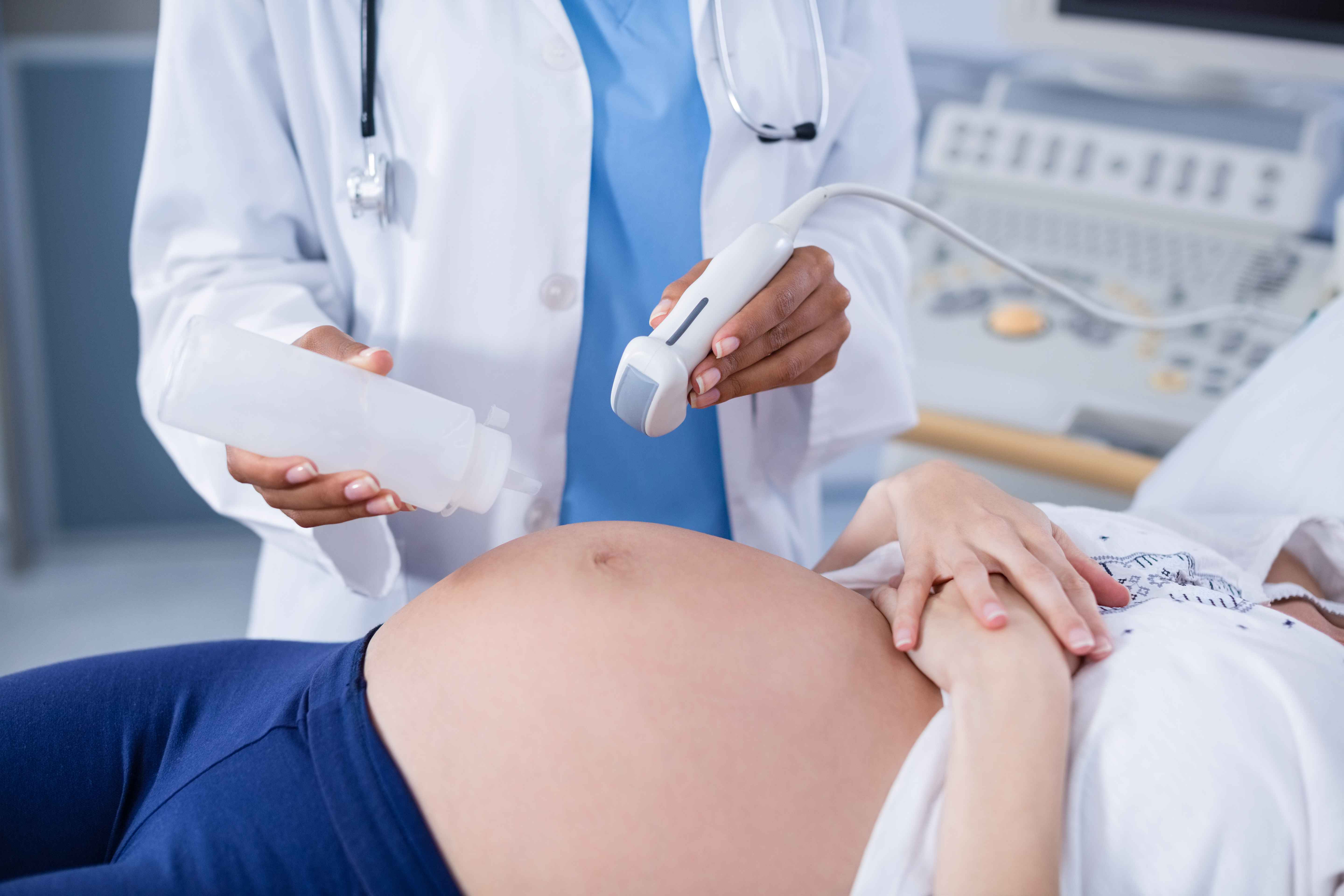 Mulher grávida fazendo ultrassom abdominal.